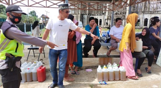 Polsek Bersama Warga Menunjuk Jerry Can yang Berisi Minyak Goreng Curah, Minggu (10/04/2022), (Foto: V24/AL)