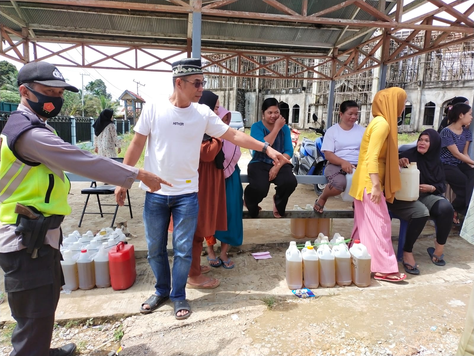 Polsek Bersama Warga Menunjuk Jerry Can yang Berisi Minyak Goreng Curah, Minggu (10/04/2022), (Foto: V24/AL)