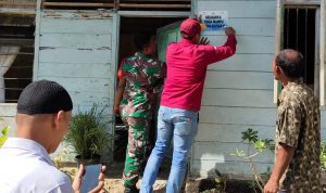 Koptu Hadi Purnomo Bersama Perangkat Desa Melakukan Pemasangan Stiker, Minggu (22/05/2022), (Foto: V24/AL)
