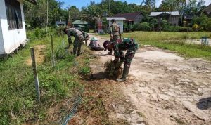 Anggota Satgas Pos Langau 1 Bantu Warga Bersihkan Jalan Desa, Senin (30/05/2022), (Foto: V24/AL)